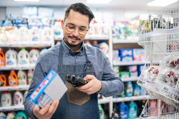 Image qui représente un homme dans un magasin. Il scanne un code-barres avec son lecteur de code-barres