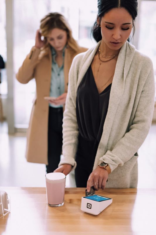 Image qui représente une femme dans un magasin avec des terminaux de paiement