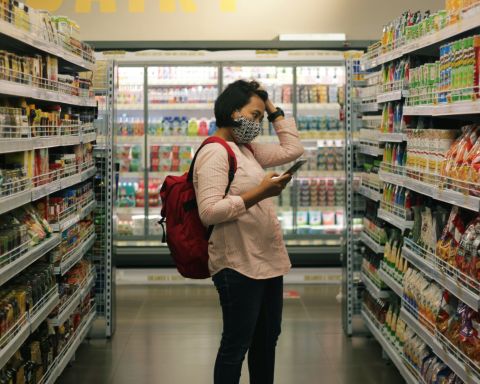 une femme devant une caisse supermarché