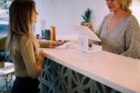 Image qui représente une femme dans un magasin avec des terminaux de paiement